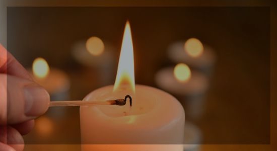 A hand igniting a candle flame symbolizing inner strength, motivation, and the power to start change.